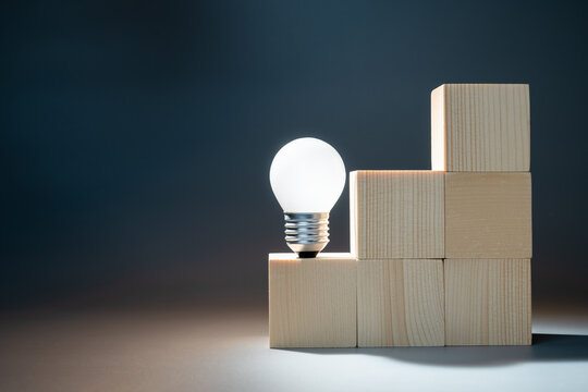 A light bulb is glowing at the first step of the stairs, knowledge is power, creative idea, inspiration to start the things to success
