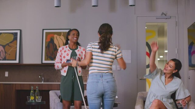 Woman cheers with friends after a winning swing on a golf simulator