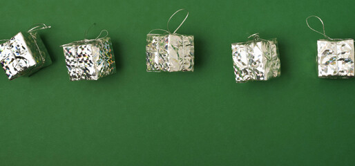 Banner. Christmas toys silver gifts on a green background. Holidays and Christmas concept.
