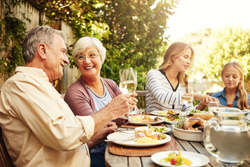 Grandparents, family and toast with wine, lunch together and home backyard with smile. Thanksgiving, celebration and mother with child on holiday, festival and vacation for tradition and bonding