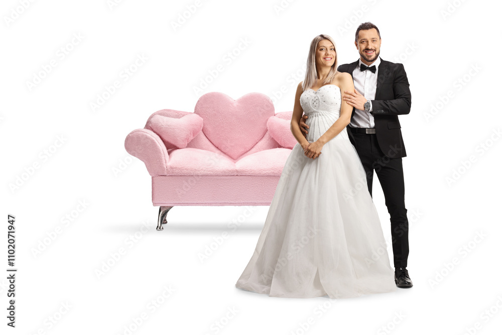 Poster Full length portrait of a bride and groom posing in front of a pink sofa