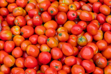 Pile of ripe and delicious red cherry tomatoes, a small round variety of tomato that is nutritionally valuable.