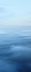 Obraz premium Misty morning fog rolling in over a light blue ocean, abstract, soft focus, serene, foggy, calming