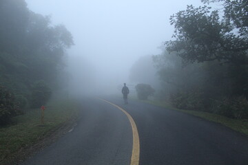 silhueta de homem caminhando em estrada com neblina  - na estrada da graciosa, paraná 