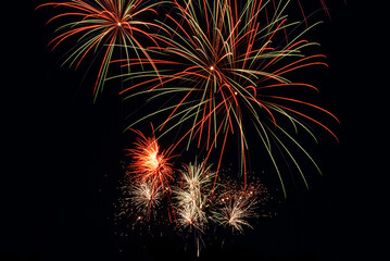 A dazzling display of fireworks lighting up the night sky with vibrant bursts of red, gold, green, and blue. Long exposure of a new years day celebration 