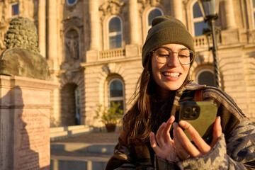 Young, beautiful woman using a mobile phone outdoors in a beautiful city. Travel concept