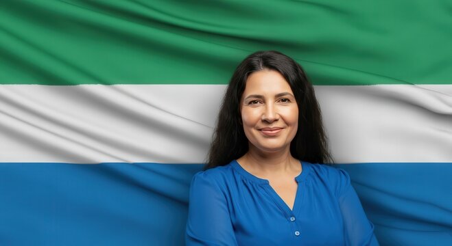 Confident woman in blue blouse standing against sierra leone flag for cultural representation and diversity
