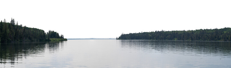 Calm lake reflecting evergreen trees along the shore with a transparent sky
