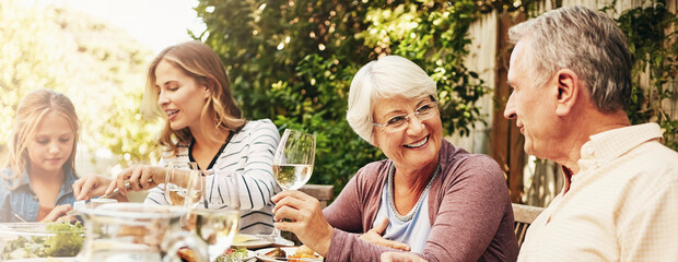 Grandparents, mother and child in backyard for lunch, eating and share meal together in garden....
