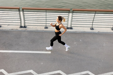 Runner enjoying a morning jog along the waterfront promenade in an urban setting