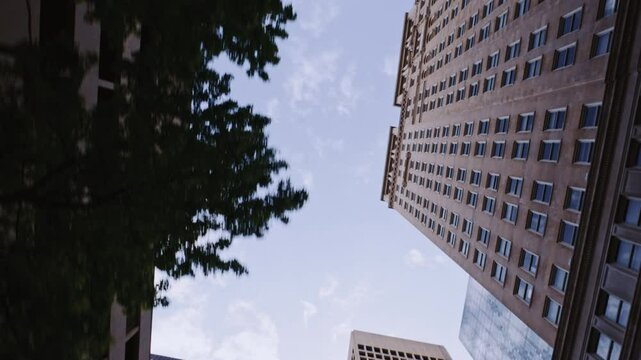 POV looking up at tall city buildings while moving