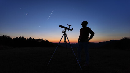 Amateur astronomer looking at the evening skies, observing planets, stars, Moon and other celestial...