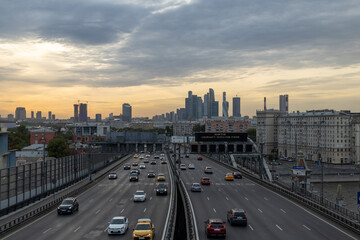 A busy city street in Moscow, Russia, filled with a plethora of traffic under a cloudy sky, creating a dynamic urban scene. Translation - Drivers obey the speed limit, Kutuzovskiy, ring, Andreevskiy