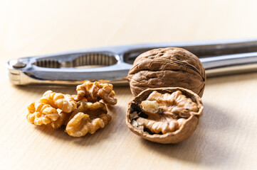 Shelled walnuts, kernels next to in-shell walnuts and nutcrackers. Production, consumption of walnuts, nutrition and properties of walnuts.