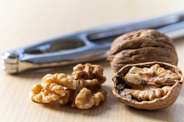 Shelled walnuts, kernels next to in-shell walnuts and nutcrackers. Production, consumption of walnuts, nutrition and properties of walnuts.