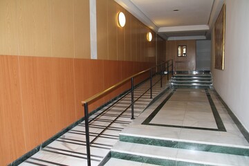 Pasillo de portal de lujo con escalones y acceso para discapacitados con larga barandilla de...