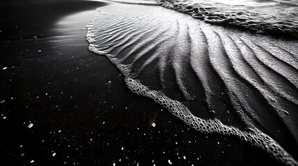 A detailed view of intricate ripple patterns created by the wind on a black sand beach