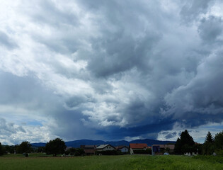 Obraz premium dark gray clouds over houses. Slovenia. Sky before storm