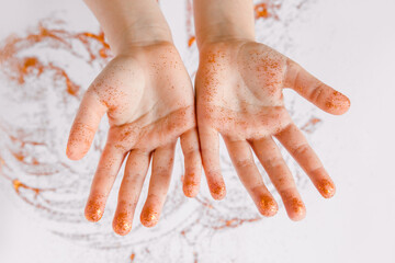 Children's hands in glitter. The  Miracle, magic of Christmas concept. White background. Top view. Crafts for Christmas and New Year, creativity.