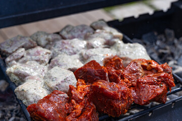 A close-up view of marinated meat grilling on a hot charcoal grill.