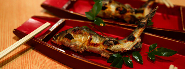 Ayu fish grilled with soft salt, Japanese local and tradition food restaurant. waterfall or river fish. freshness and healthy eating ingredient. Japan healthy lifestyle menu. burn or smoke cookery.