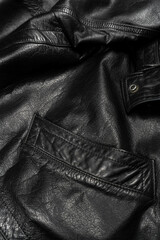Detailed view of a black leather jacket pocket with sleek stitching.