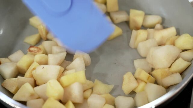 the pastry chef cooks the apples in a pan to make jam for the cake
