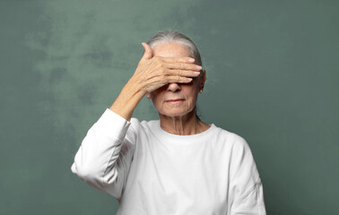  covering eyes with one hand feeling scared or anxious, wondering or blindly waiting for a surprise