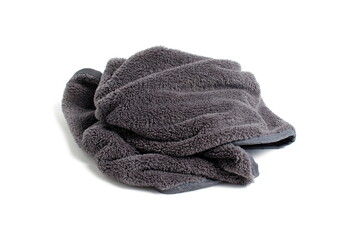 A small grey towel lies crumpled on a white background.	