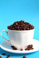 A cup with coffee beans stands on a blue background.	
