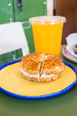 Toasted sesame bagel with cream cheese on plate with orange juice,Fresh baked New York style bagels,london bagel,Three Different Types of Bagels in cafe,baked sourdough,Brunch bakery shop.