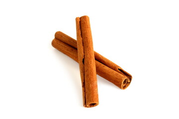  On a white background lie spices, two cinnamon sticks.