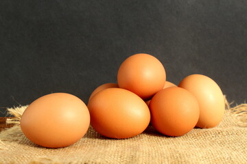 There are brown chicken eggs on a wooden table.