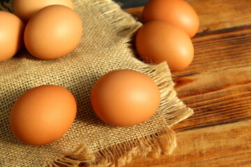 There are brown chicken eggs on a wooden table.