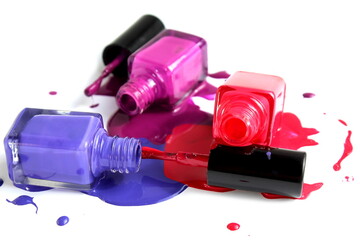 Open spill varnish of three colors in glass bottles is located on a white background.	