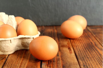 There are brown chicken eggs on a wooden table.