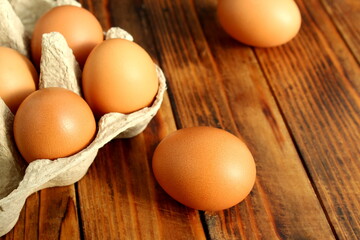 There are brown chicken eggs on a wooden table.