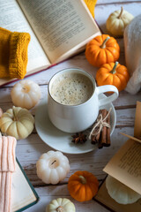 A cup of coffee and lots of books, pumpkins, autumn mood. Calendar for the 25th year.