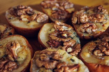 Baked pears topped with walnuts and blue cheese, capturing a rustic and comforting feel