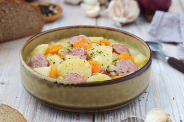 A bowl with traditional German potato soup with sausages