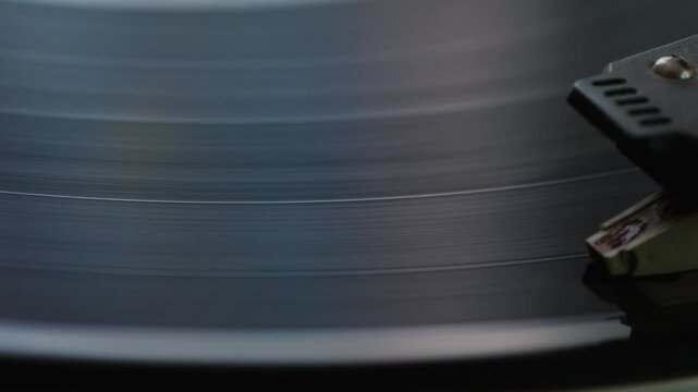 close up of spinning vinyl record in turntable, retro vinyl disc playing music