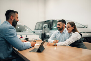 Smiling couple finalizing car purchase, feeling triumphant.