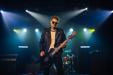 Male guitarist performing on stage with electric guitar