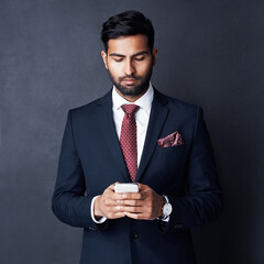 Entrepreneur, phone and business man in studio for communication, contact and networking. Corporate fashion, gray background and isolated person on smartphone for email, social media and website
