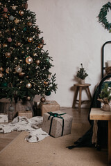 Beautifully wrapped presents in soft colors are placed under a sparkling Christmas tree. The setting exudes a warm, festive atmosphere perfect for holiday celebrations.