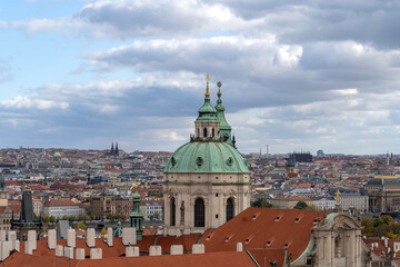 Fototapeta premium Prague's historical architecture, with the St Nicholas' baroque church towers and dome at Mala strana, offering a glimpse into the city's past.