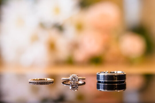 Bride and Groom Wedding Rings in Front of Flowers