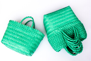 Green traditional woven tote bag isolated on white background. Bright concept product photography.