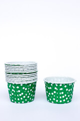 Cupcake muffin cases pack isolated on white background, front view. Green polka dot pattern greaseproof paper baking cups.