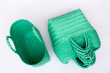 Green traditional woven tote bag isolated on white background. Bright concept product photography.